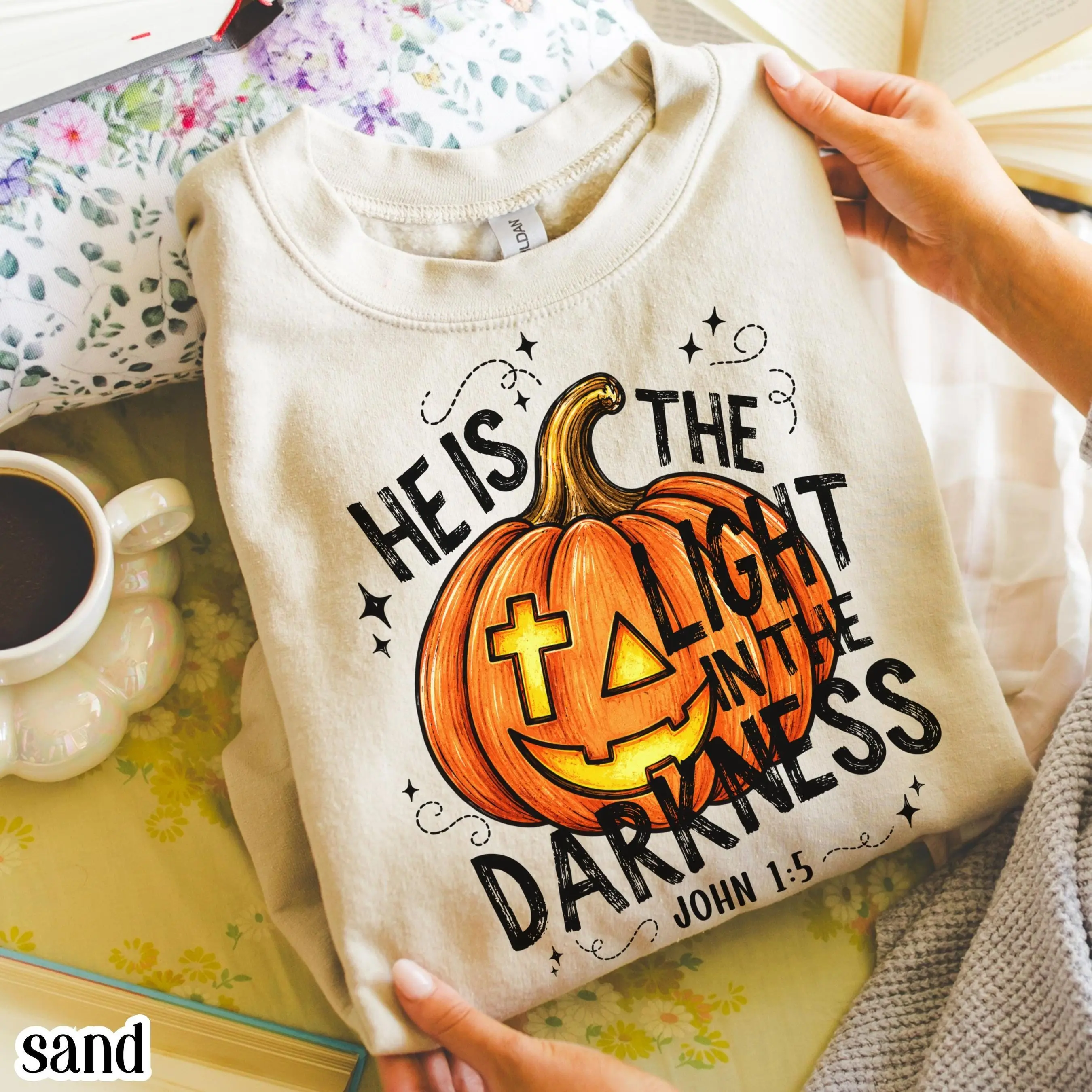 He Is The Light In The Darkness Christian Halloween Sweatshirt, John 1:5 Faith Pumpkin Fall Bible Verse Crewneck